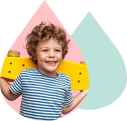 A smiling child carrying a yellow skateboard